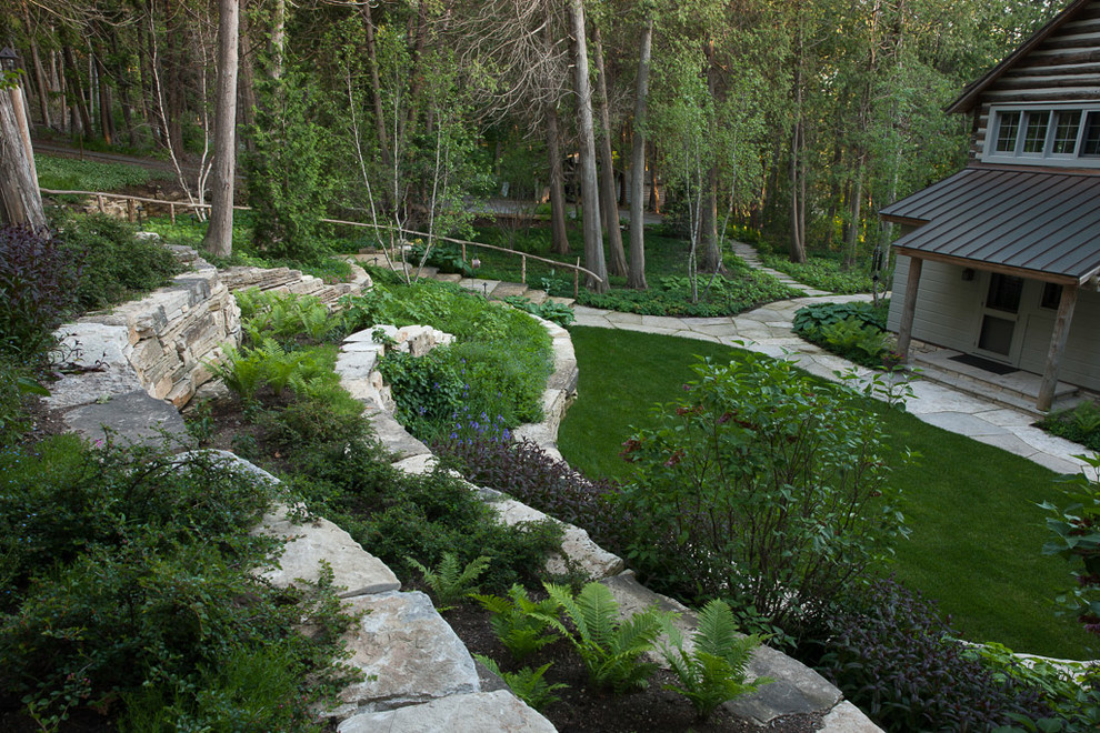 Design ideas for a large rustic partial sun front yard stone retaining wall landscape for summer.