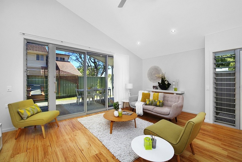 This is an example of a small transitional open concept living room in Central Coast with white walls and vinyl floors.