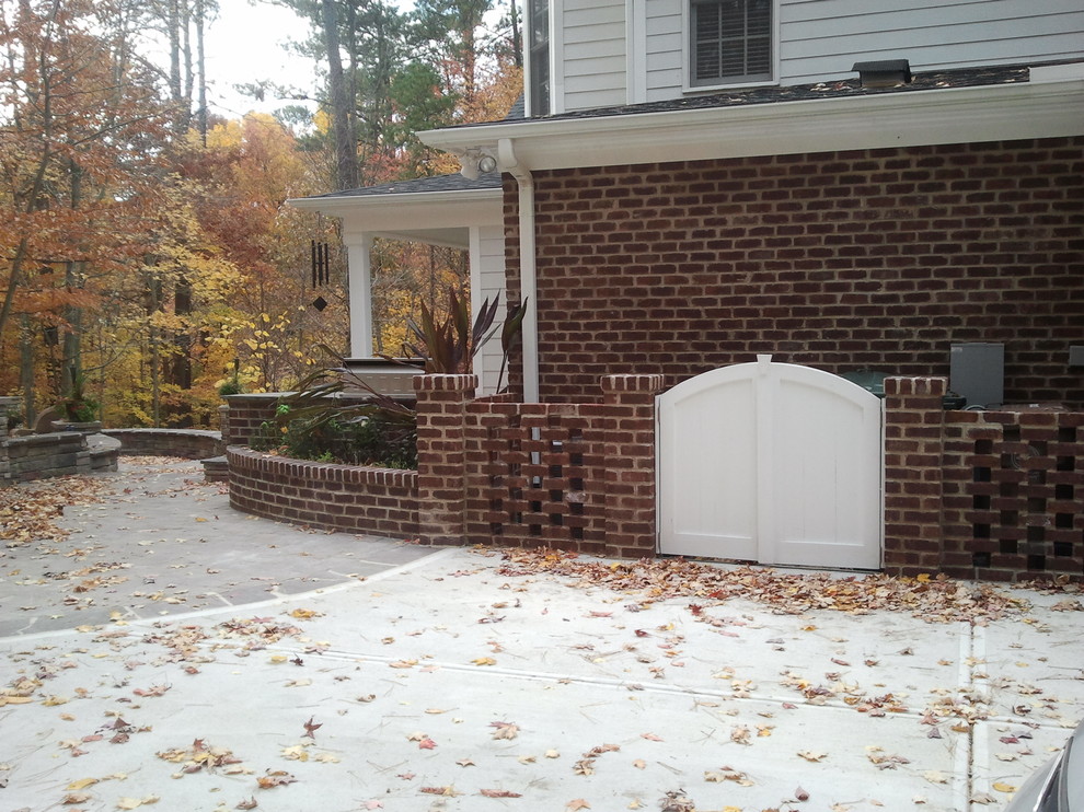 This is an example of a mid-sized traditional two-storey brick white exterior in Raleigh with a hip roof.