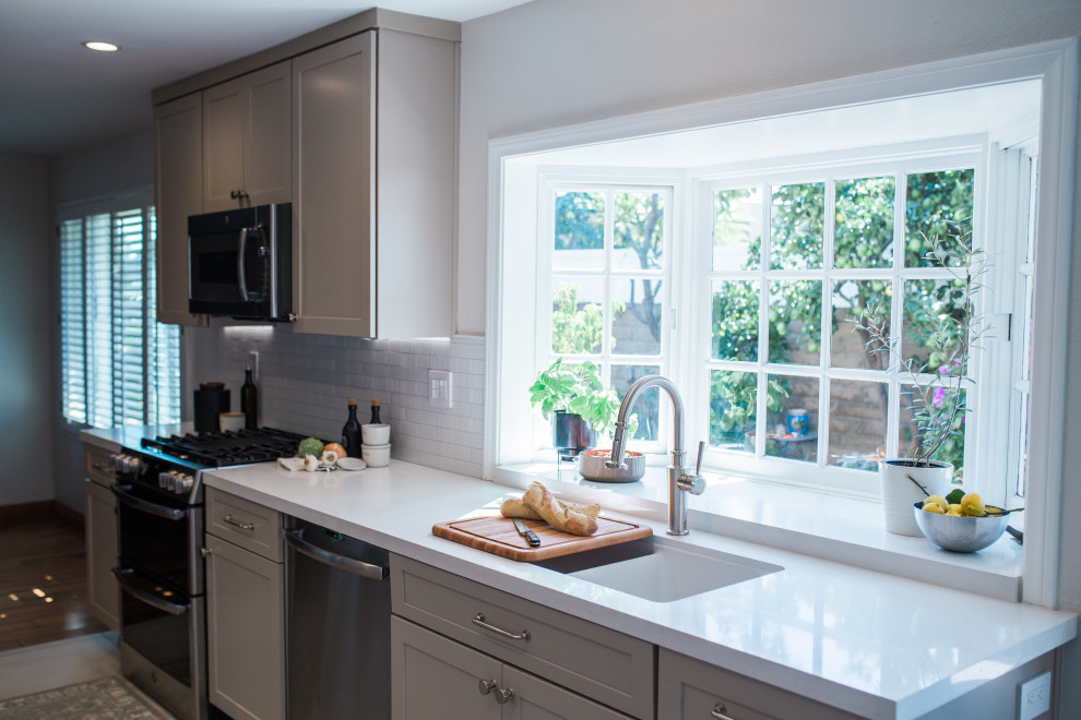 Inspiration for a small transitional galley porcelain tile and beige floor open concept kitchen remodel in Orange County with a double-bowl sink, shaker cabinets, beige cabinets, quartz countertops, white backsplash, subway tile backsplash, stainless steel appliances, no island and white countertops