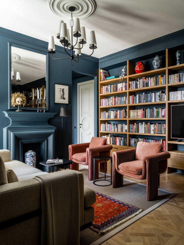 На фото: гостиная комната в стиле неоклассика (современная классика) с с книжными шкафами и полками, синими стенами, стандартным камином, скрытым телевизором, зоной отдыха и акцентной стеной с