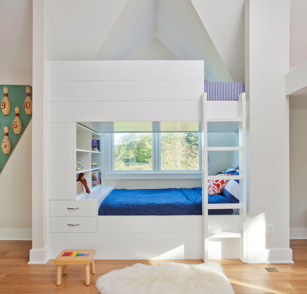 Large traditional kids' bedroom in Chicago with white walls and light hardwood floors for kids 4-10 years old and boys.