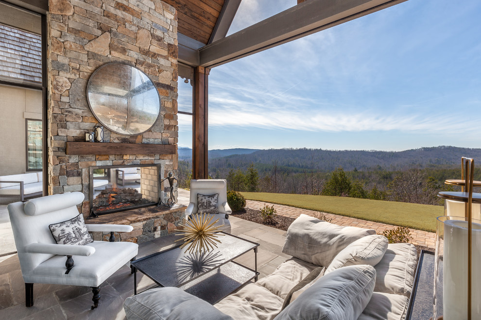 This is an example of a country backyard patio in Other with with fireplace.