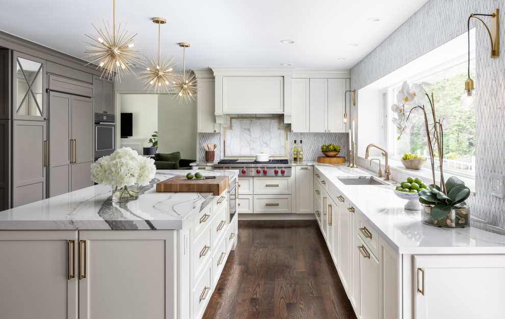 Large classic galley kitchen/diner in Detroit with a submerged sink, recessed-panel cabinets, white cabinets, engineered stone countertops, white splashback, stone tiled splashback, stainless steel appliances, dark hardwood flooring, an island, brown floors and white worktops.