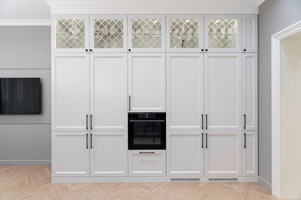 Imagen de cocina comedor tradicional renovada de tamaño medio con armarios tipo vitrina, puertas de armario blancas, electrodomésticos blancos y una isla