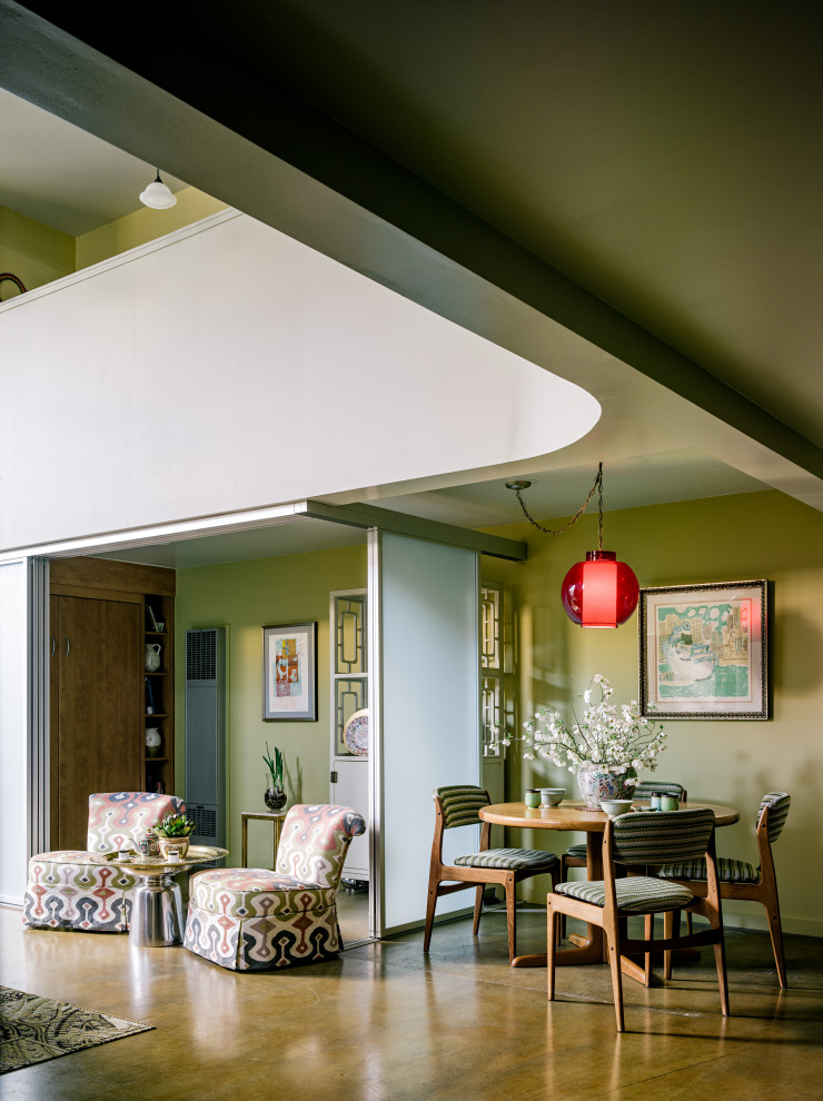 Cette photo montre une petite salle à manger ouverte sur le salon éclectique en bois avec un mur vert, sol en béton ciré, un sol beige et un plafond en bois.