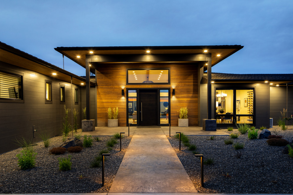 Inspiration pour une grande façade de maison grise minimaliste de plain-pied avec un revêtement mixte, un toit à quatre pans, un toit en shingle et un toit noir.