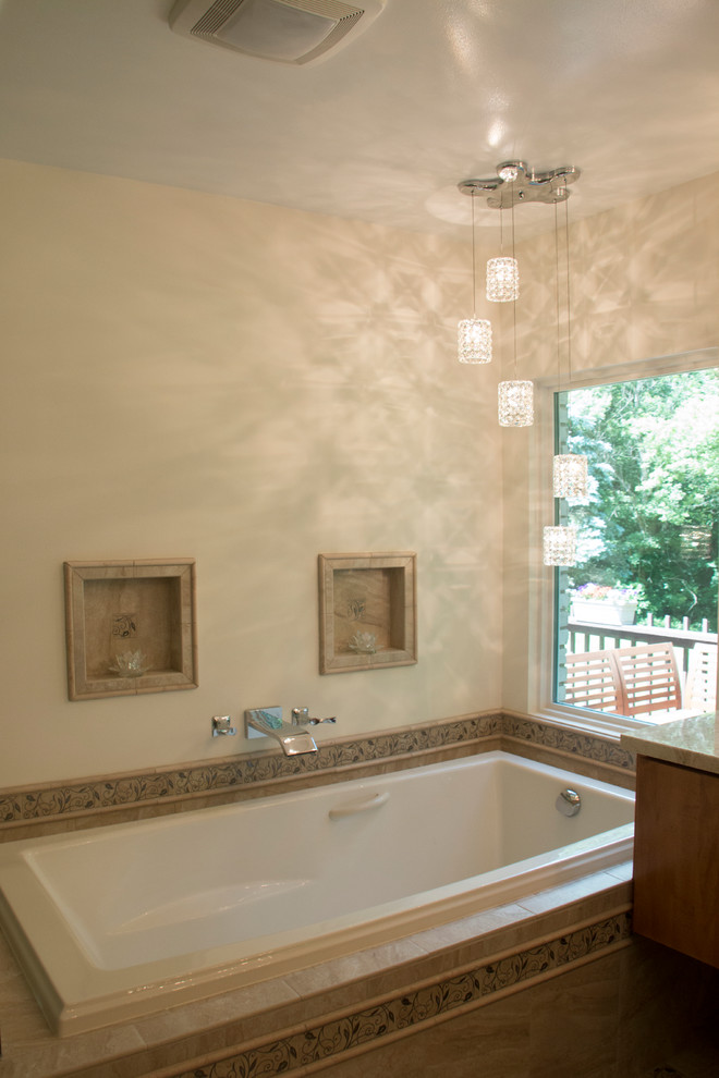 Inspiration for a mid-sized transitional master beige tile and ceramic tile ceramic tile drop-in bathtub remodel with an undermount sink, flat-panel cabinets, light wood cabinets, solid surface countertops, a two-piece toilet and beige walls