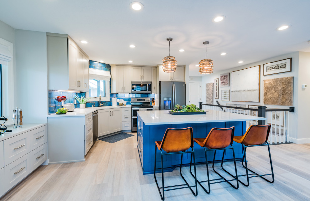 Photo of a small eclectic l-shaped open plan kitchen in Minneapolis with an undermount sink, shaker cabinets, blue cabinets, quartzite benchtops, blue splashback, ceramic splashback, coloured appliances, vinyl floors, with island, beige floor and white benchtop.
