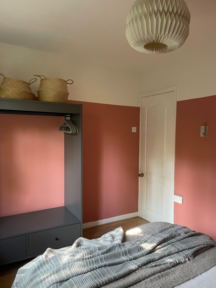 Réalisation d'une petite chambre d'amis méditerranéenne avec un mur rose, sol en stratifié et un sol beige.