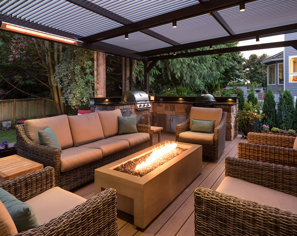 This is an example of a large transitional backyard deck in Seattle with an outdoor kitchen and a pergola.