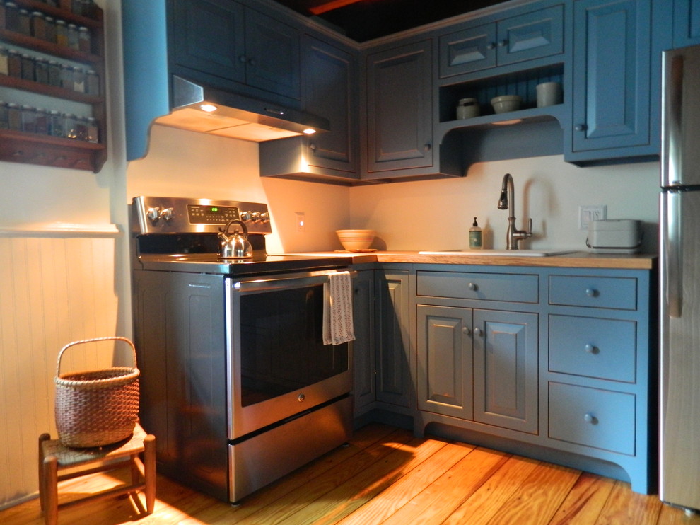 Photo of a small country l-shaped eat-in kitchen in Philadelphia with blue cabinets and wood benchtops.