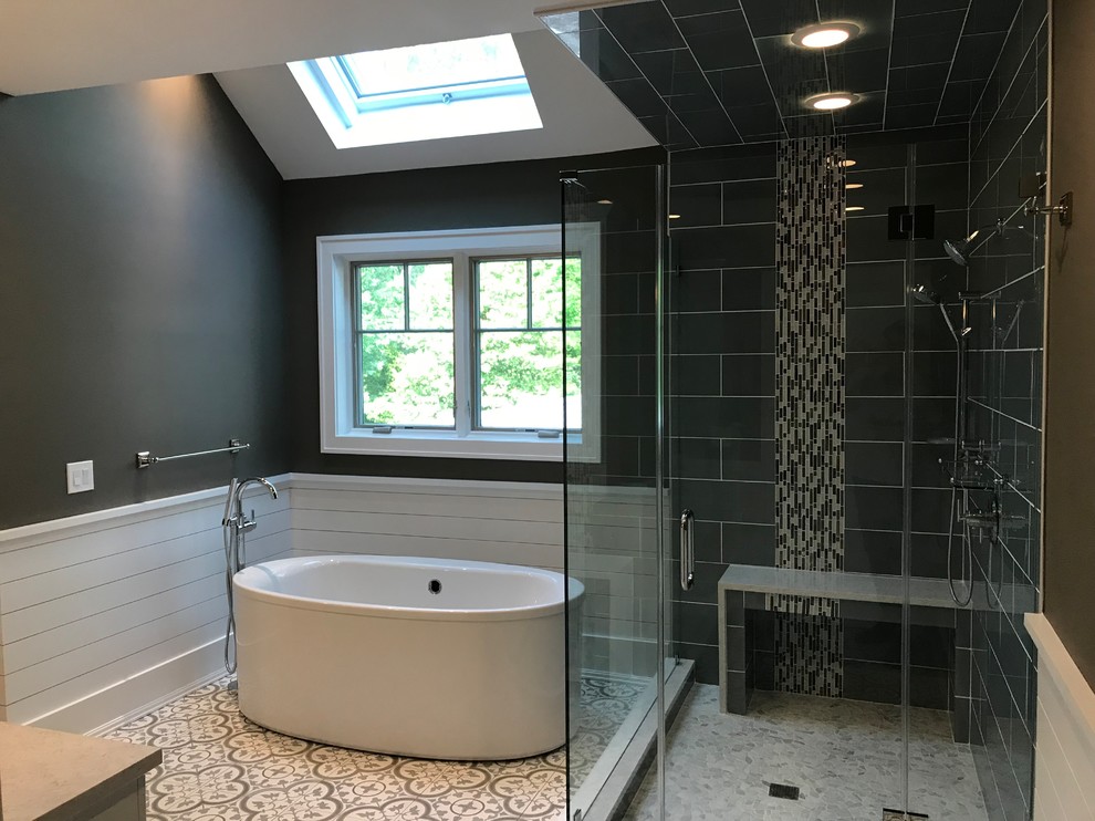 This is an example of a mid-sized contemporary master bathroom in New York with raised-panel cabinets, white cabinets, a freestanding tub, a corner shower, gray tile, porcelain tile, brown walls, ceramic floors, an undermount sink, multi-coloured floor, a hinged shower door and beige benchtops.