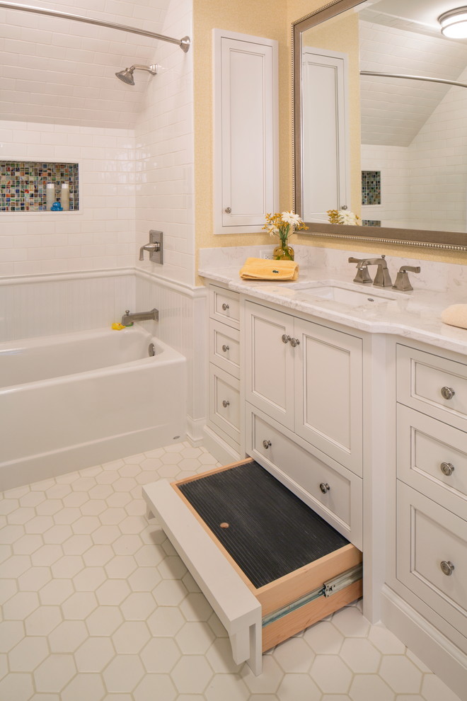 This is an example of a mid-sized traditional kids bathroom in Omaha with beaded inset cabinets, an alcove tub, white tile, porcelain tile, white walls, porcelain floors, a drop-in sink and granite benchtops.