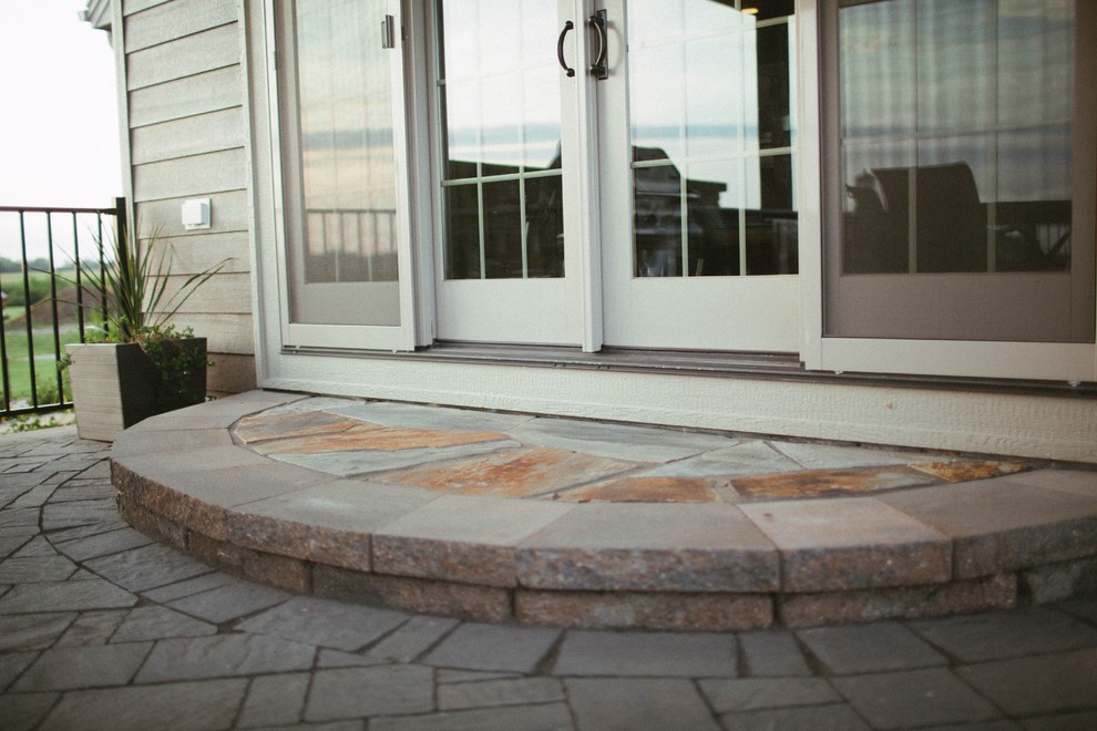 Patio kitchen - rustic backyard concrete paver patio kitchen idea with a roof extension