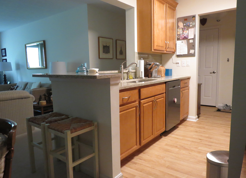 Small transitional galley vinyl floor and brown floor enclosed kitchen photo with an undermount sink, raised-panel cabinets, light wood cabinets, quartz countertops, beige backsplash, glass tile backsplash, stainless steel appliances, no island and beige countertops