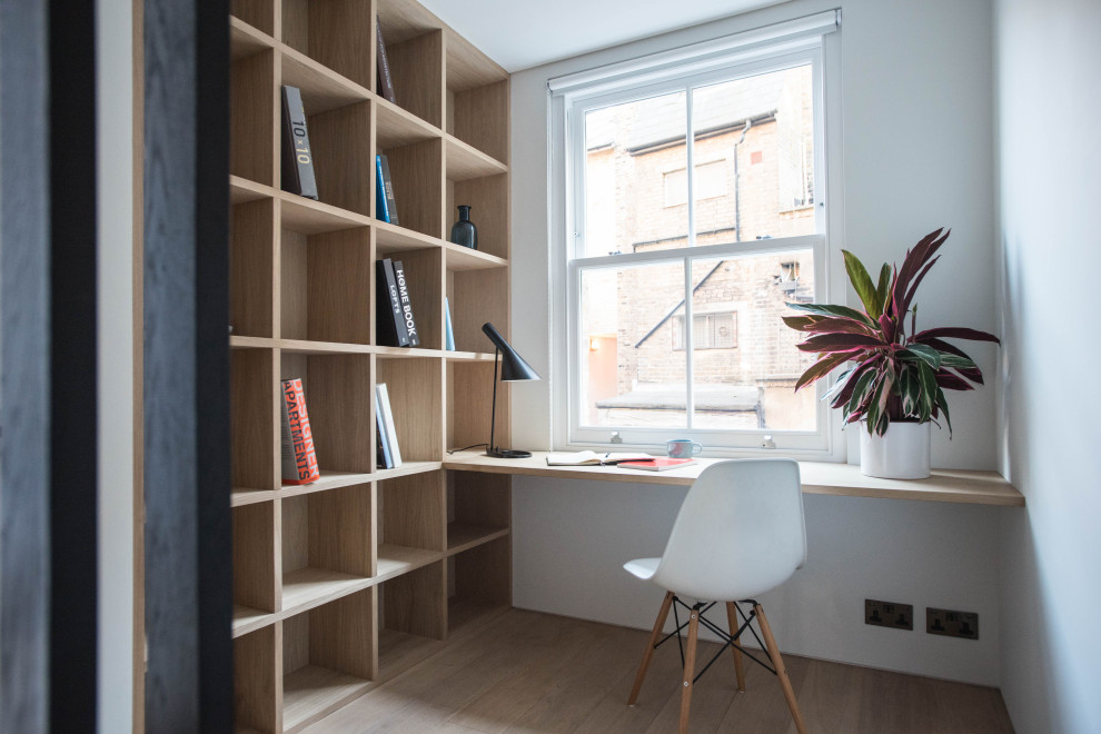 Idée de décoration pour un bureau nordique de taille moyenne avec un mur blanc, parquet clair, un bureau intégré et un sol beige.