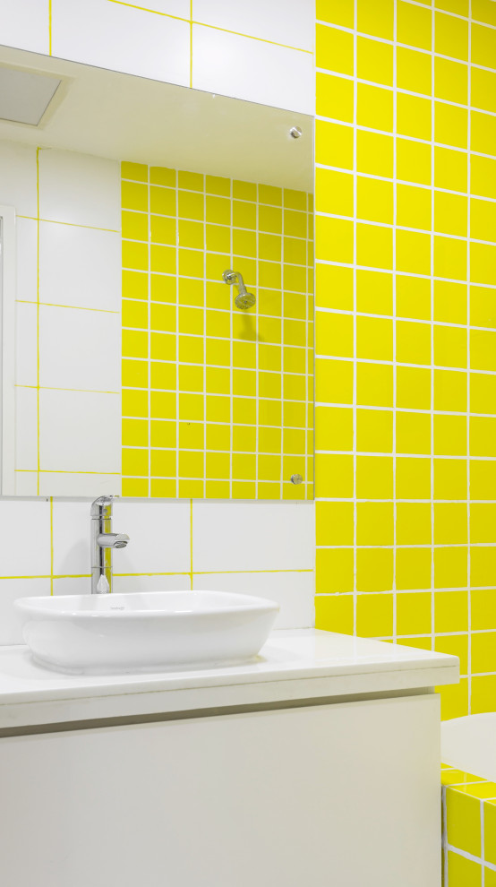 This is an example of a contemporary bathroom with flat-panel cabinets, white cabinets, yellow tile, a vessel sink, white benchtops, a single vanity and a floating vanity.