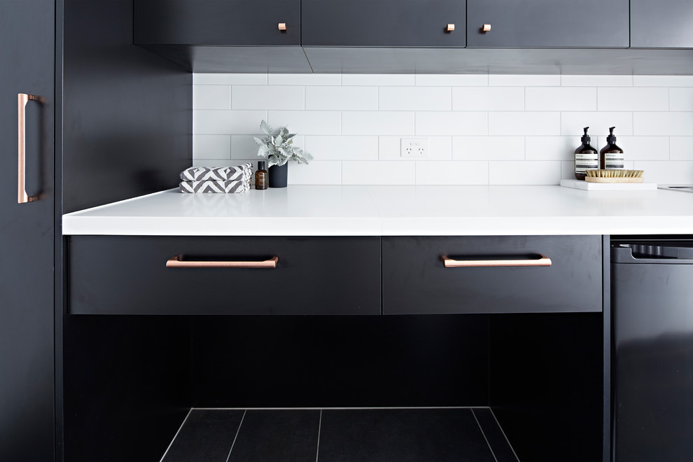 This is an example of a mid-sized modern single-wall kitchen in Melbourne with an undermount sink, black cabinets, black floor, white benchtop and quartz benchtops.