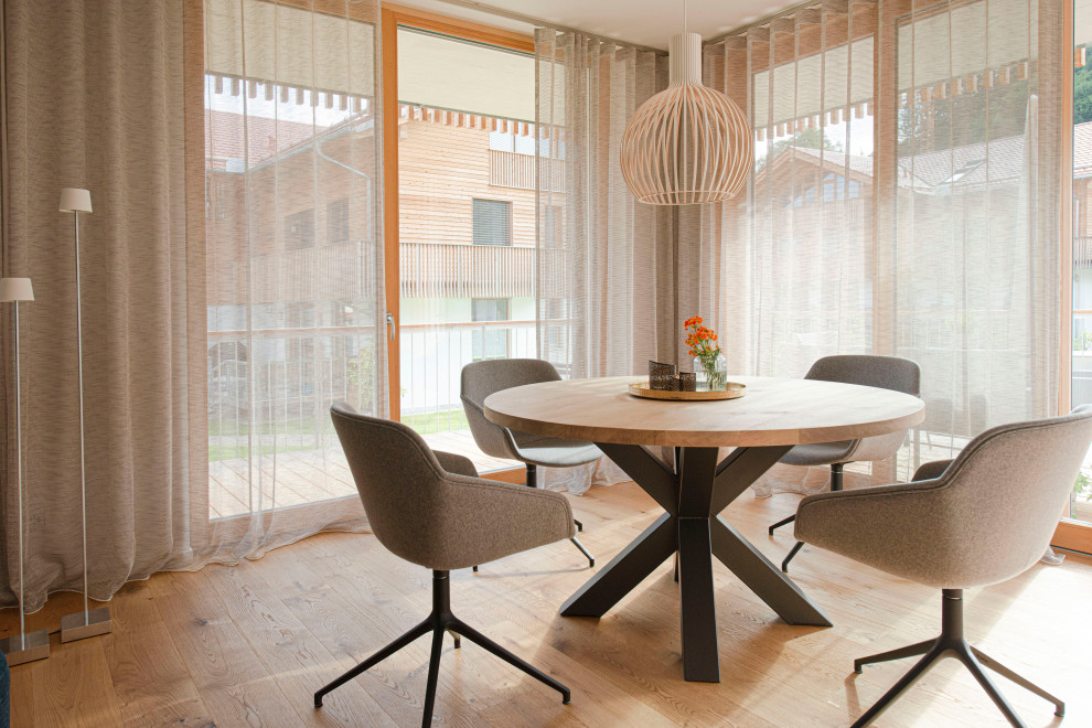 На фото: гостиная-столовая среднего размера в современном стиле с деревянным полом и коричневым полом