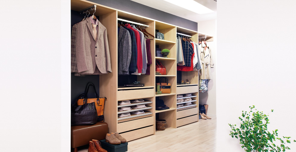 Photo of a modern gender-neutral walk-in wardrobe in Other with open cabinets, light wood cabinets and light hardwood floors.