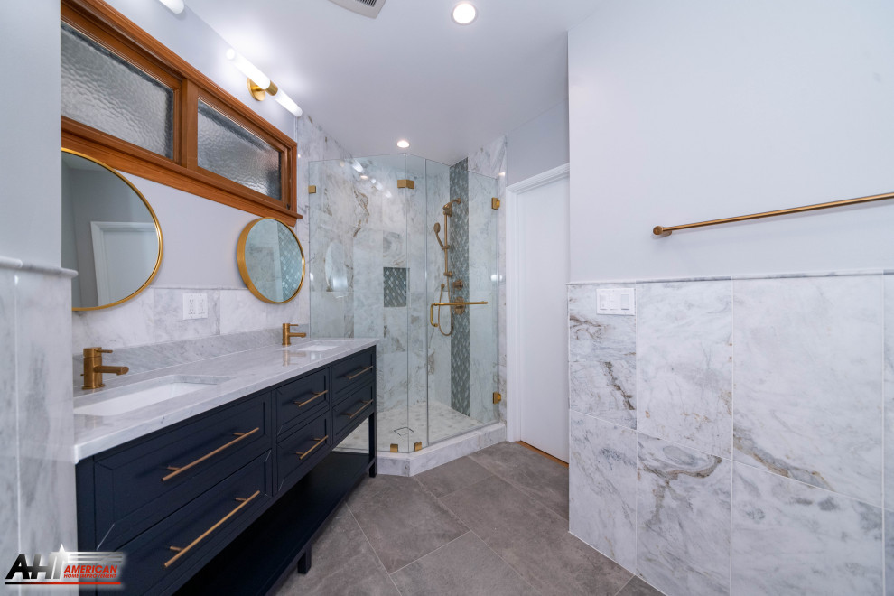 Large modern master bathroom in Los Angeles with furniture-like cabinets, blue cabinets, a corner shower, a one-piece toilet, white tile, marble, white walls, porcelain floors, an undermount sink, marble benchtops, grey floor, a hinged shower door, white benchtops, a double vanity, a freestanding vanity and recessed.