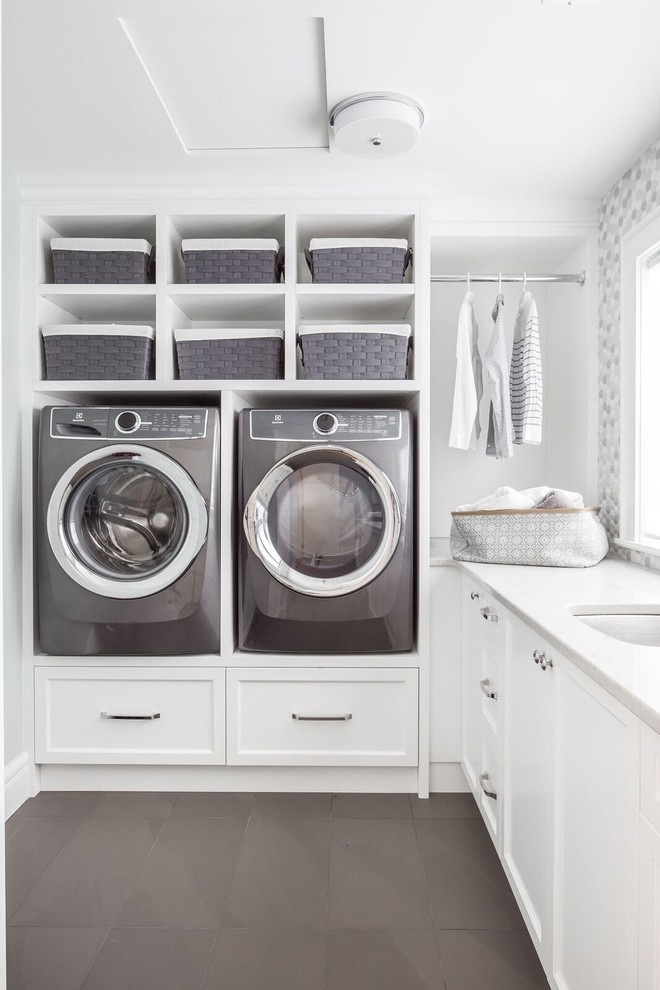 Design ideas for a transitional l-shaped dedicated laundry room in Vancouver with an undermount sink, shaker cabinets, white cabinets, white walls, a side-by-side washer and dryer, grey floor and white benchtop.