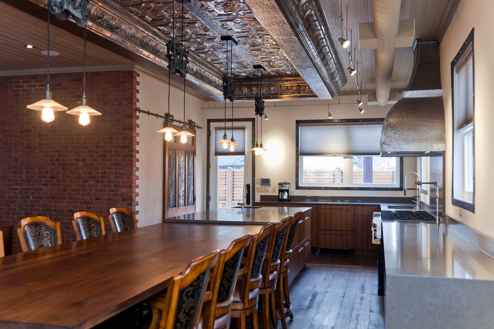 Photo of an industrial l-shaped eat-in kitchen in Toronto with flat-panel cabinets, medium wood cabinets, quartz benchtops and an undermount sink.