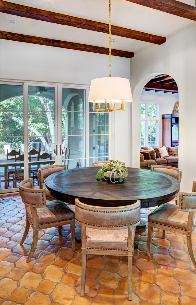 Photo of a mediterranean dining room in Dallas with white walls and terra-cotta floors.