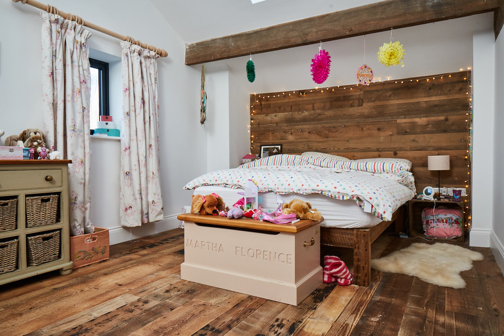 Design ideas for a mid-sized country kids' bedroom for kids 4-10 years old and girls in Other with white walls, light hardwood floors and brown floor.