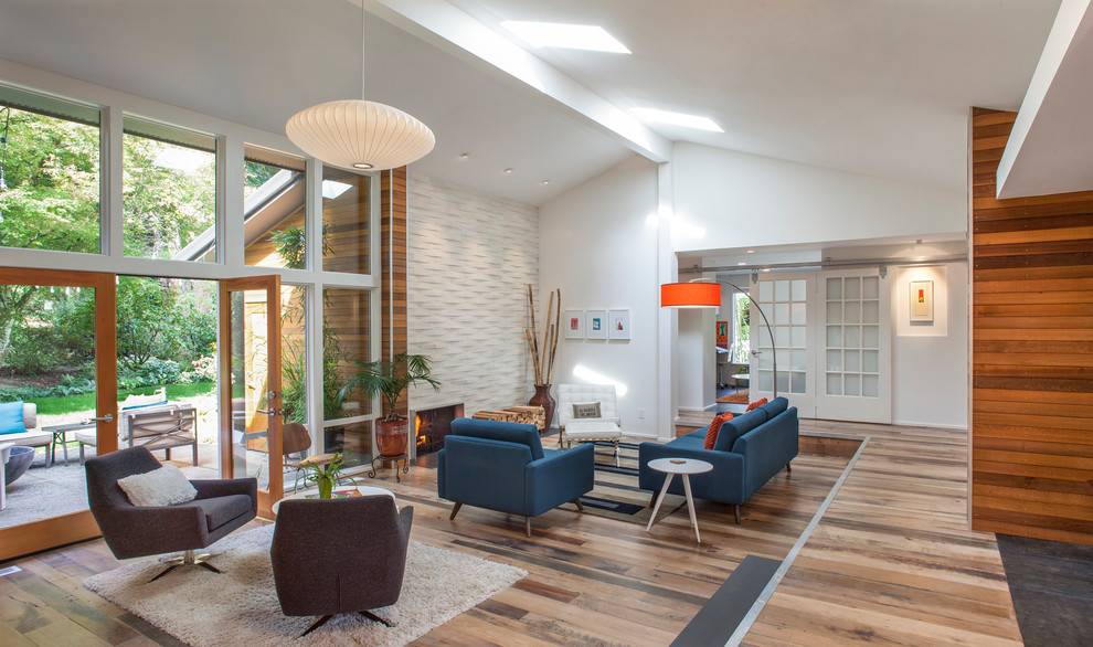 Photo of a large midcentury open concept living room in Portland with white walls, a metal fireplace surround and a ribbon fireplace.
