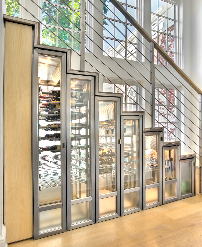 Design ideas for a mid-sized beach style wine cellar in New York with light hardwood floors, storage racks and beige floor.