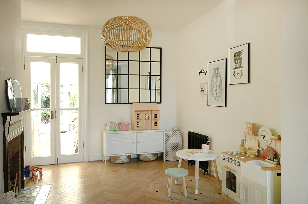 Photo of a mid-sized scandinavian kids' playroom for kids 4-10 years old and girls in Surrey with white walls, light hardwood floors and beige floor.