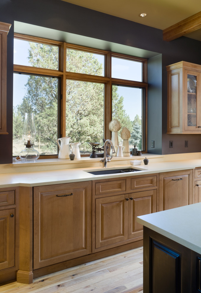 This is an example of a country kitchen in Portland with raised-panel cabinets.