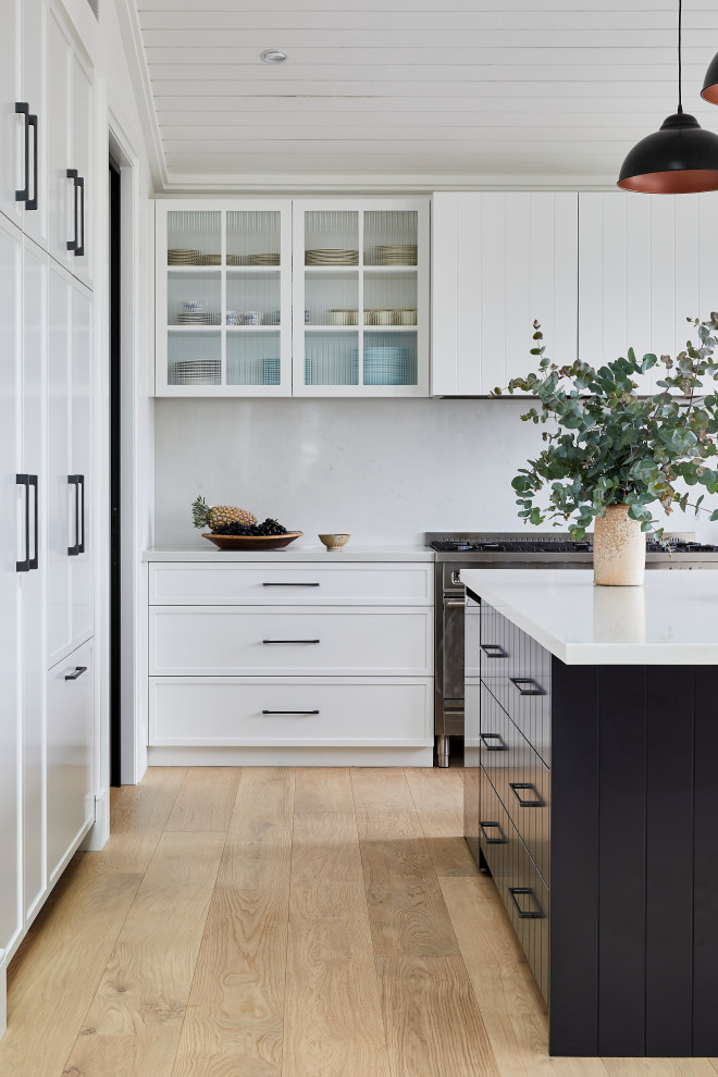 This is an example of a large rural u-shaped open plan kitchen in Sydney with a submerged sink, shaker cabinets, white cabinets, marble worktops, white splashback, marble splashback, integrated appliances, light hardwood flooring, an island, brown floors, white worktops and a vaulted ceiling.