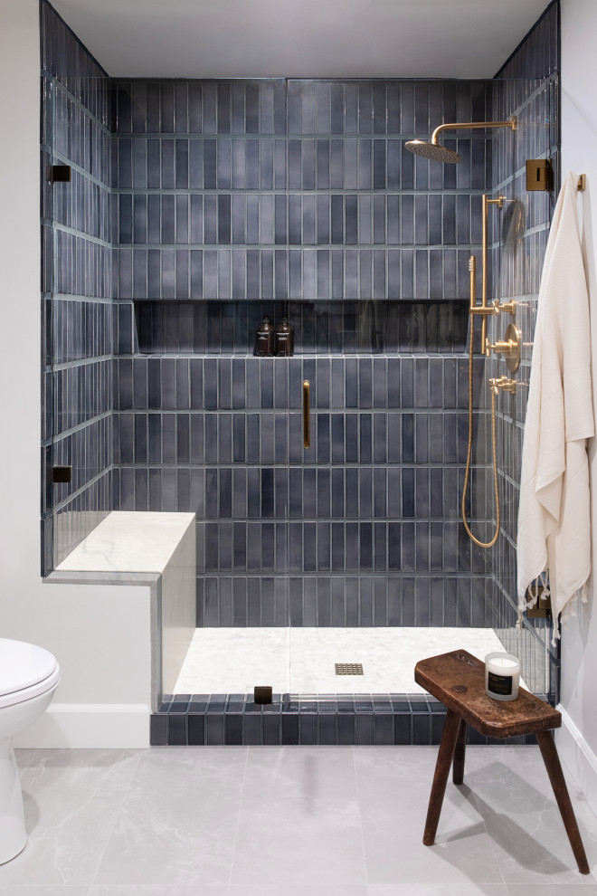 На фото: большая ванная комната в стиле неоклассика (современная классика) с фасадами в стиле шейкер, серыми фасадами, унитазом-моноблоком, синей плиткой, керамогранитной плиткой, белыми стенами, полом из керамической плитки, врезной раковиной, столешницей из кварцита, серым полом, серой столешницей, сиденьем для душа, тумбой под две раковины и встроенной тумбой с