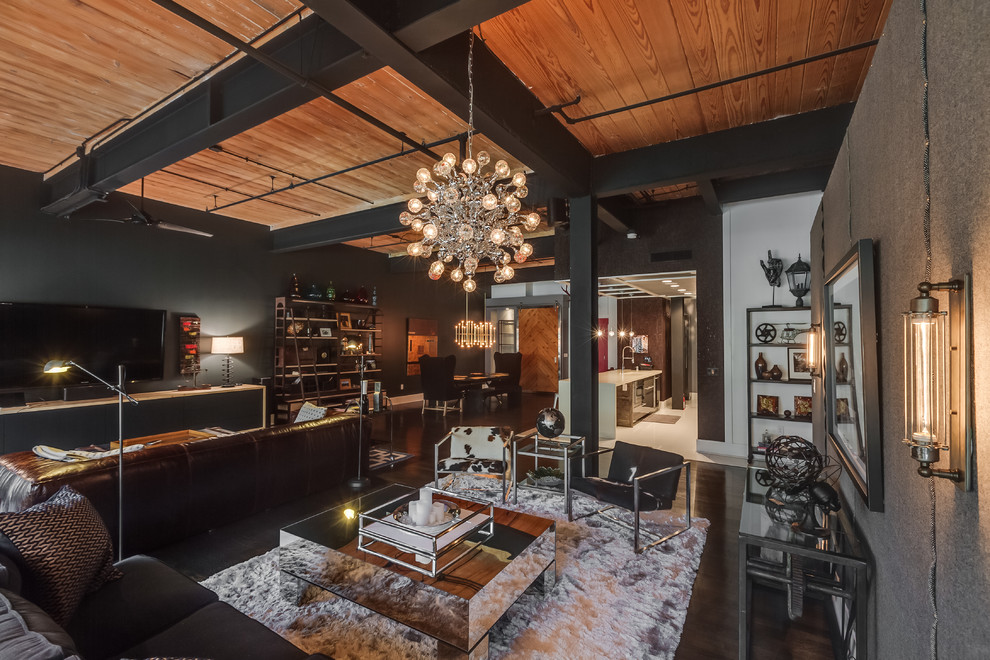 Design ideas for a large industrial open concept living room in Charlotte with black walls, painted wood floors, no fireplace, a wall-mounted tv and black floor.