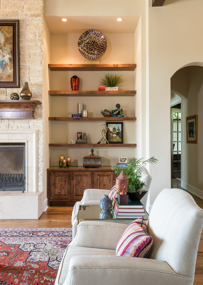This is an example of a large open concept living room in Austin with medium hardwood floors, a standard fireplace, a tile fireplace surround and a wall-mounted tv.