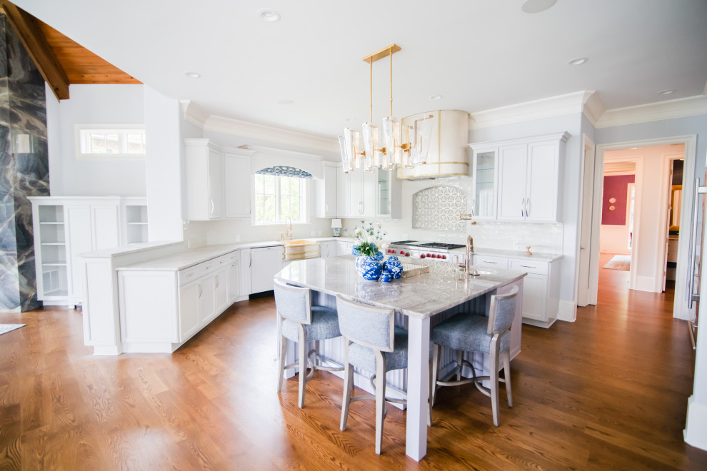 Inspiration for a large transitional u-shaped eat-in kitchen in Charlotte with a farmhouse sink, recessed-panel cabinets, grey cabinets, quartzite benchtops, grey splashback, subway tile splashback, stainless steel appliances, medium hardwood floors, with island, brown floor and purple benchtop.
