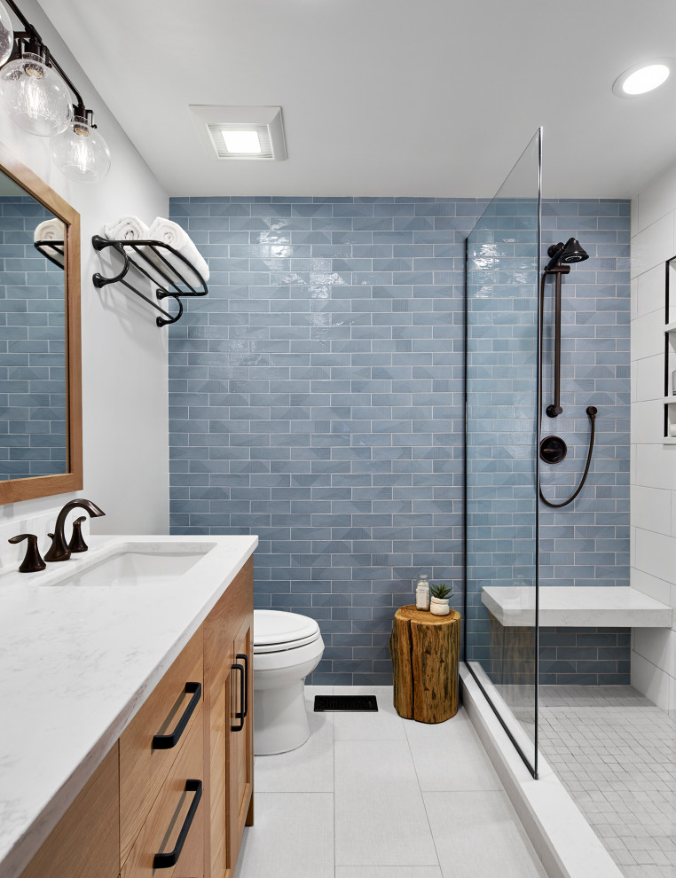 Photo of a mid-sized transitional master bathroom in Chicago with light wood cabinets, blue tile, white walls, white floor, white benchtops, shaker cabinets, an alcove shower, ceramic tile, porcelain floors, an undermount sink, engineered quartz benchtops, a hinged shower door, a double vanity and a built-in vanity.