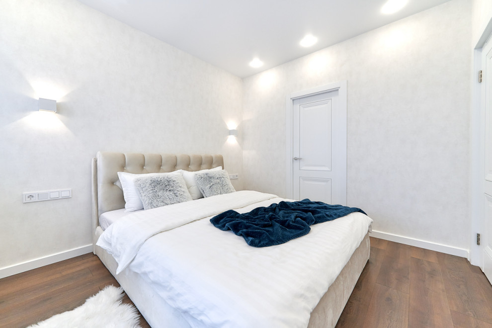На фото: хозяйская спальня среднего размера: освещение в современном стиле с белыми стенами, полом из ламината, коричневым полом и обоями на стенах без камина