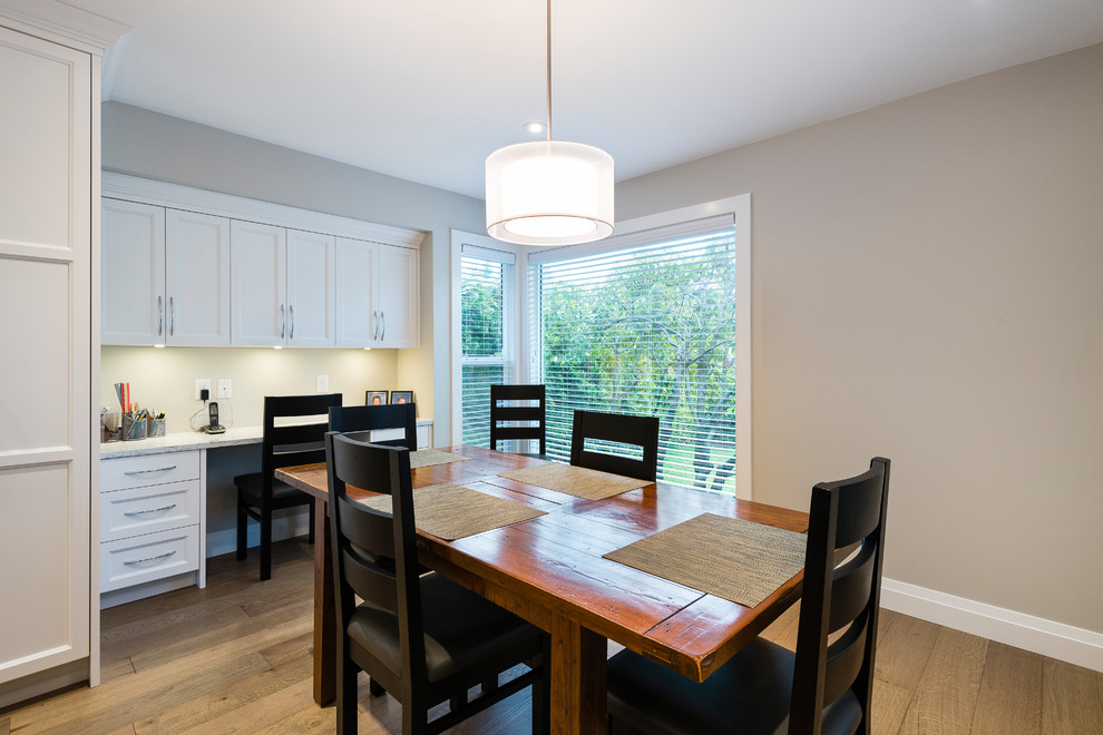 Example of a mid-sized transitional l-shaped light wood floor and brown floor open concept kitchen design in Vancouver with an undermount sink, shaker cabinets, white cabinets, quartz countertops, multicolored backsplash, mosaic tile backsplash, stainless steel appliances and an island