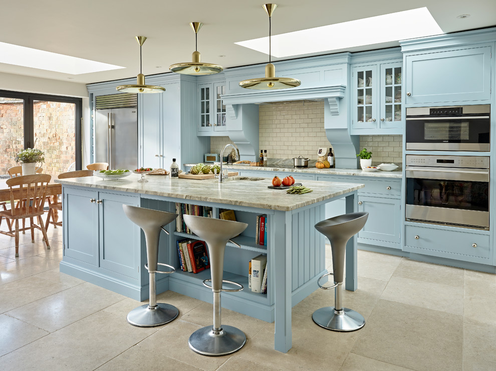 This is an example of a traditional l-shaped open plan kitchen in Oxfordshire with shaker cabinets, blue cabinets, granite benchtops, stainless steel appliances, with island and a single-bowl sink.