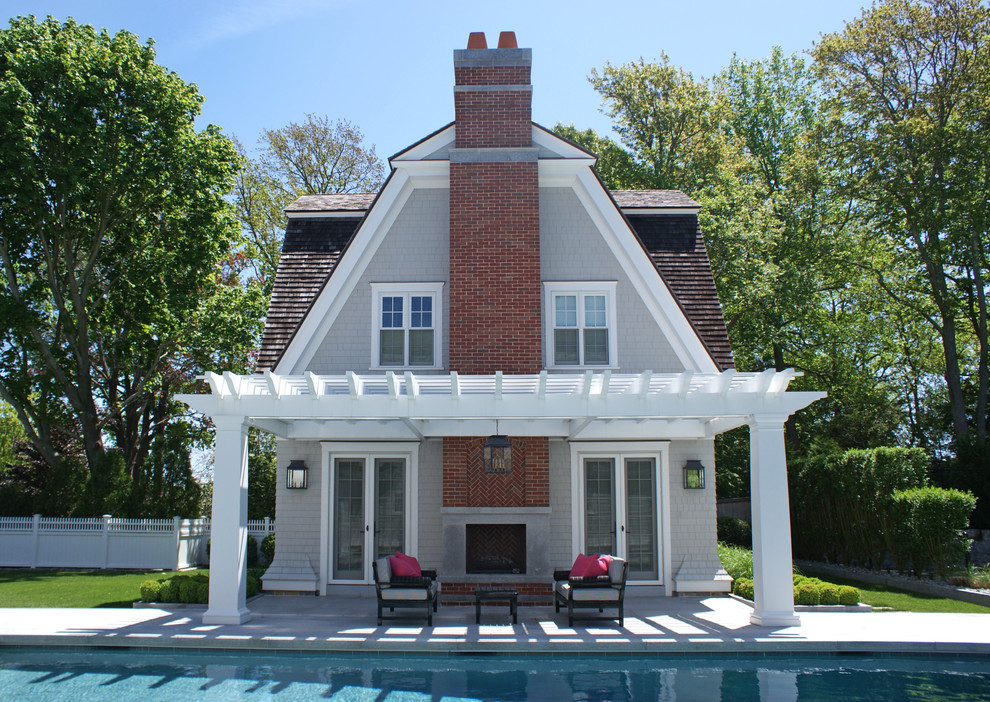 Large transitional courtyard custom-shaped pool in Boston with a pool house and natural stone pavers.