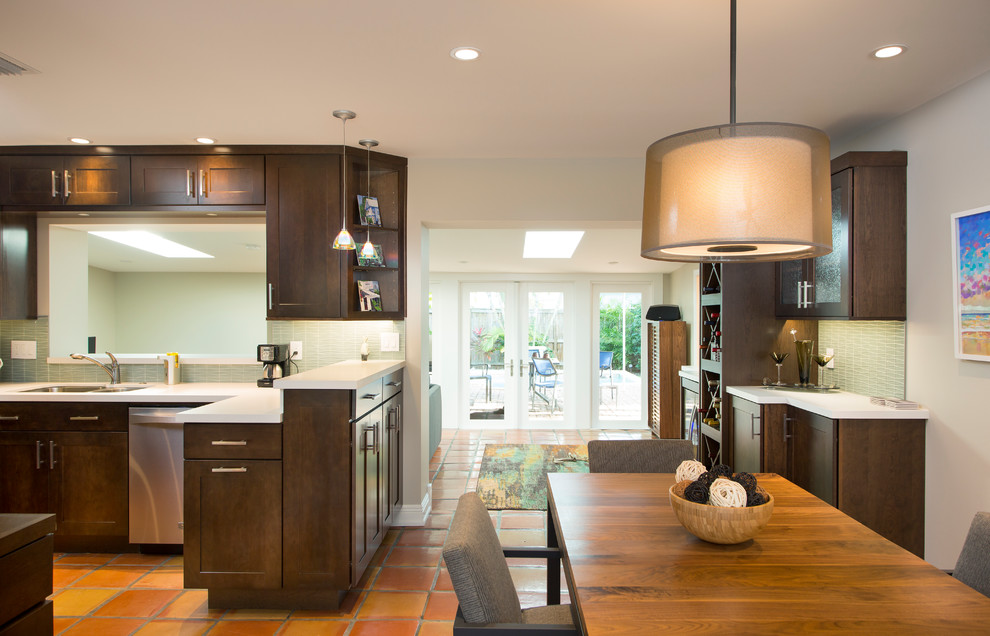 Small transitional u-shaped terra-cotta tile eat-in kitchen photo in Miami with an undermount sink, shaker cabinets, dark wood cabinets, quartz countertops, green backsplash, glass tile backsplash and stainless steel appliances