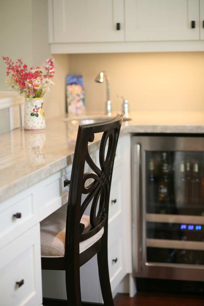 Example of a large transitional l-shaped dark wood floor and brown floor eat-in kitchen design in Toronto with an undermount sink, shaker cabinets, white cabinets, stainless steel appliances and an island