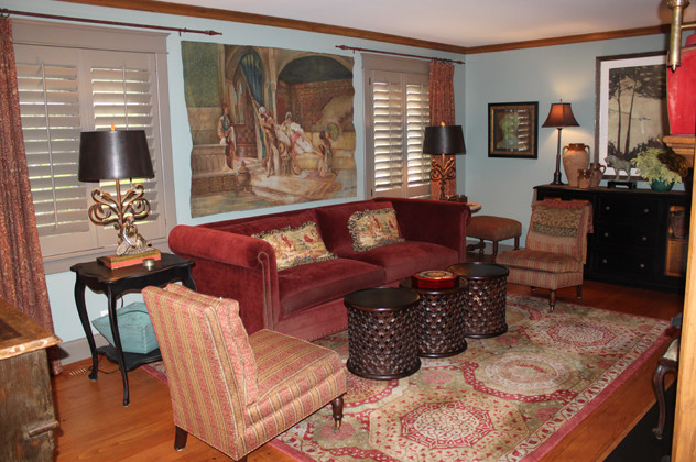 This is an example of a mid-sized country formal enclosed living room in Chicago with blue walls, medium hardwood floors, a standard fireplace, a wood fireplace surround and no tv.