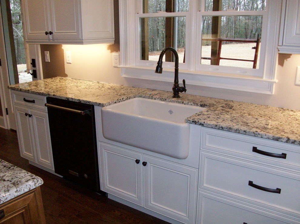 Inspiration for a mid-sized u-shaped separate kitchen in Atlanta with a farmhouse sink, recessed-panel cabinets, white cabinets, granite benchtops, brick splashback, black appliances, dark hardwood floors and with island.