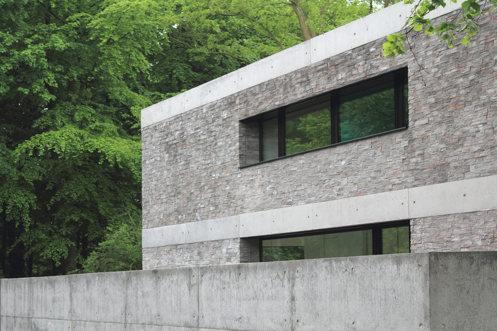 Geräumiges, Zweistöckiges Industrial Einfamilienhaus mit Steinfassade, grauer Fassadenfarbe, Flachdach und Misch-Dachdeckung in Hannover