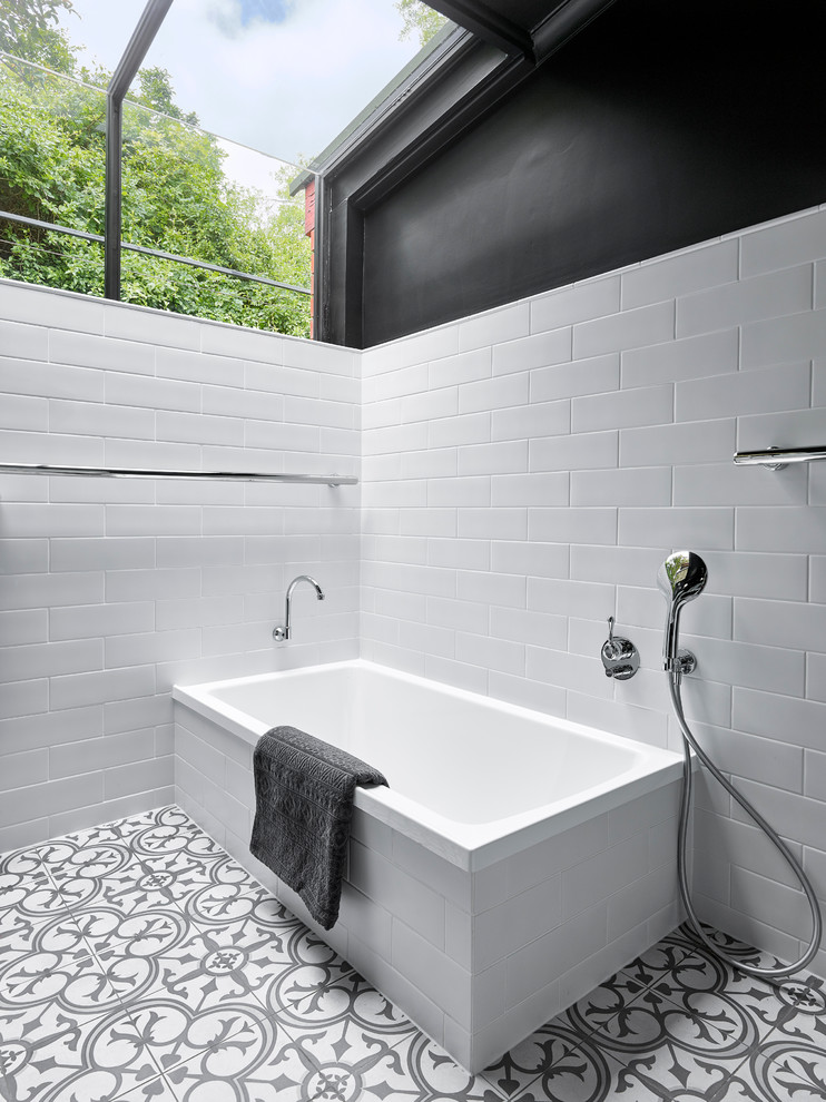 Photo of a mid-sized transitional master bathroom in Other with black cabinets, a drop-in tub, an open shower, black and white tile, white walls, porcelain floors, an undermount sink, solid surface benchtops, shaker cabinets, ceramic tile, multi-coloured floor, an open shower and white benchtops.